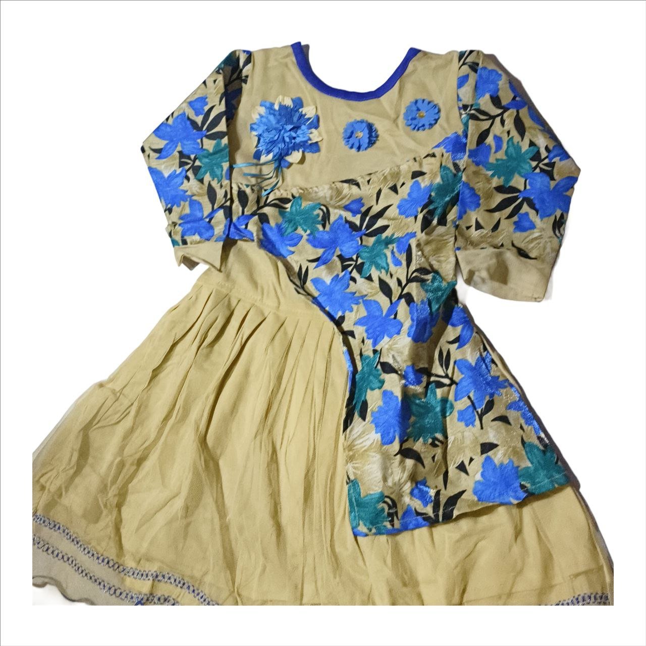 This vibrant outfit for girls combines traditional patterns with a modern, asymmetrical design. It appears to be a fusion-style lehenga choli or a designer frock, featuring a beige base with a bold, blue and teal floral print on one side.